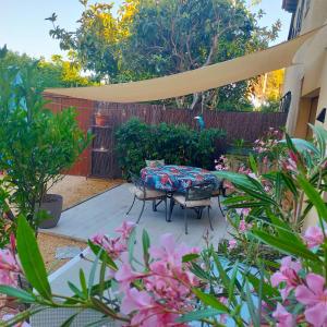 a patio with a table and chairs in a garden at Casa Francesca Altea piscina y aparcamiento privado in Altea