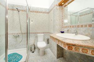a bathroom with a toilet and a sink and a shower at Mpalmpanas Villas in Ierissos