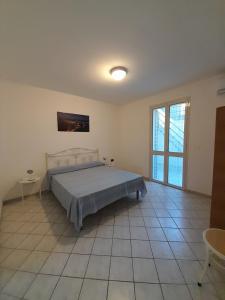 a bedroom with a bed and a large window at Il Faro di Anna in Leuca