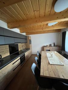 a kitchen with a wooden table and some chairs at Chata Linda in Mýto pod Ďumbierom