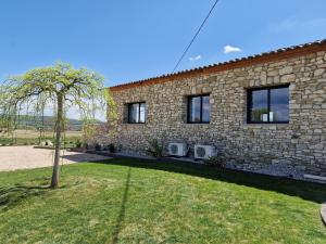 a brick house with a tree in front of it at La campagne Pramaïsse in Mane