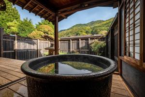 eine große runde Badewanne auf einer Holzterrasse in der Unterkunft BYAKU Narai in Shiojiri