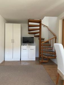 a living room with a television and a staircase at Gallery for two, near the beach and the center of Jelsa in Jelsa