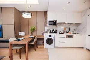 a kitchen and dining room with a table and a washer at Ascott M-City Foshan in Foshan
