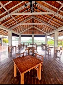 Hotel Cloud 9 Negombo في نيجومبو: غرفة كبيرة بها طاولات وكراسي وسقف