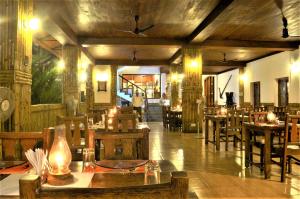 un restaurante con mesas de madera y sillas en una habitación en The Killians Boutique Hotel, en Kochi