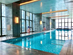 a large swimming pool in a building with windows at Ascott M-City Foshan in Foshan