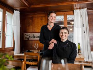 Eine Frau steht neben einem Mädchen im Esszimmer. in der Unterkunft Boutique-Hotel Schlüssel in Beckenried