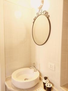 een badkamer met een wastafel en een spiegel aan de muur bij Holiday Alghero Old Town in Alghero