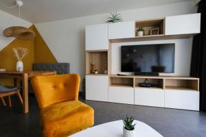 sala de estar con TV y silla en Location Commodore Oostende, en Ostende
