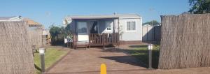 a small house behind a fence with a gate at Casa Prefabricada in El Palmar +6 photos