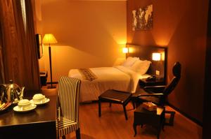 a hotel room with a bed and a table and chair at Tat Place Hotel in Kuala Belait