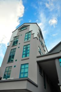 a tall white building with windows on top of it at Tat Place Hotel in Kuala Belait