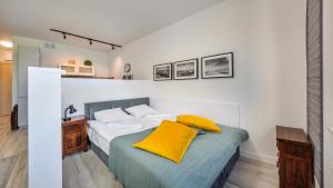 ein Schlafzimmer mit einem Bett mit gelbem Kissen darauf in der Unterkunft Apartamenty Sun & Snow Katamarany Zatoka in Puck