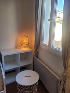 Habitación con taburete blanco y ventana en Aix-en-Provence Superbe studio centre historique, en Aix-en-Provence