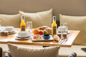 a table with bottles of wine and a plate of food at Urban Style Victoria Boutique Hotel in Arcachon