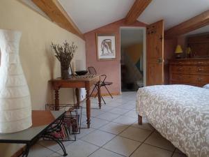 um quarto com uma cama e uma mesa num quarto em Le gite de l'impassiflore em Méounes-lès-Montrieux