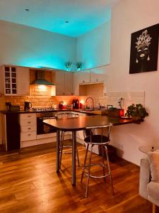 a kitchen with a table and two bar stools at Southsea Retreat in Southsea