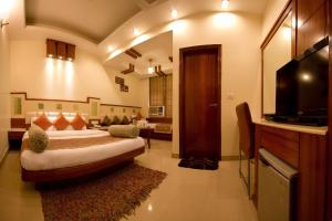 sypialnia z łóżkiem i telewizorem w pokoju w obiekcie The Aster Karol Bagh Homely Atmosphere w Nowym Delhi