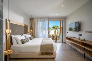 a hotel room with a bed and a television at Stella Palace Aqua Park Resort in Hersonissos