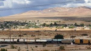 a train on a train track with mountains at Stardust Inn in Barstow