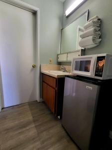 a kitchen with a refrigerator, microwave and sink at Stardust Inn in Barstow