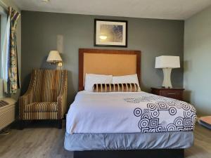 a bedroom with a large bed and a chair at Star Inn Barstow in Barstow