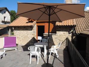 a patio with a table and two chairs and an umbrella at Casa Rural Sardas 60m2 con GARAGE - Sabiñanigo in Sabiñánigo