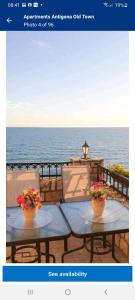 two tables with flowers on top of a balcony overlooking the ocean at Apartments Antigona Old Town in Ulcinj