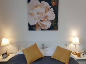a bedroom with a bed with two lamps and a flower painting at Max Studio in Sancraiu de Mures
