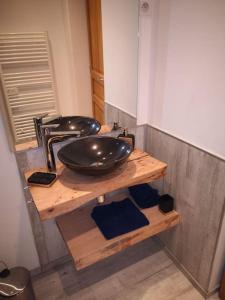 La salle de bains est pourvue d'un lavabo sur un comptoir en bois. dans l'établissement chambre d'hôtes nos racines (chez Muriel et Philippe), à Saulxures-sur-Moselotte