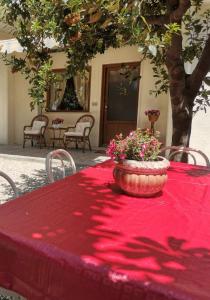 Una mesa roja con una maceta de flores. en Al Centesimo Chilometro - Ristoro del Pellegrino, en Montefiascone