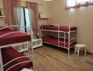 um quarto com 3 beliches com lençóis vermelhos em Al Centesimo Chilometro - Ristoro del Pellegrino em Montefiascone