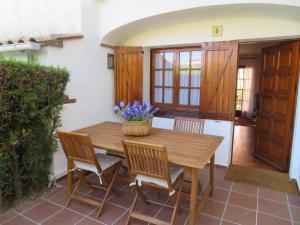 Une table et des chaises en bois sont disponibles sur la terrasse. dans l'établissement Torre Bonica, à Torroella de Montgrí