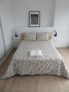 - une chambre avec un lit et 2 serviettes dans l'établissement Apartamento Na Beira Do Mar, à O Pindo