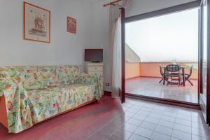 a living room with a couch and a balcony with a table at PALAU APARTMENT - HOME and MORE in Palau