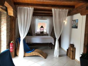 1 dormitorio con 1 cama y una ventana con cortinas en Hotel Mlyn, en Zavar