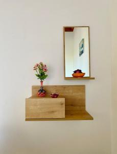 a mirror and a vase with flowers on a shelf at Casa di Vati in Vátion