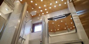 a bathroom with a shower with a mirror and a window at Apartments Bo&scaron;ković in Stari Grad