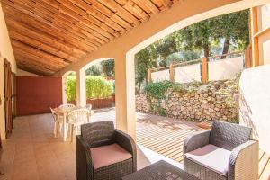 an outdoor patio with chairs and a stone wall at Le Mas des Bois in Le Muy