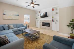sala de estar con sofá azul y mesa en Las Olas Villa with HEATED Salt Water Pool, en Fort Lauderdale