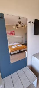 a view of a bedroom with a bed and a mirror at B&B Villa Eleonora Tropea in Le Pioppe