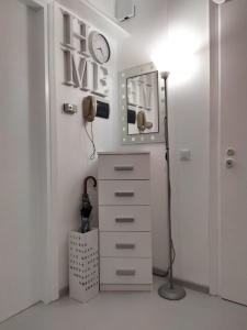 a room with a dresser and a clock on the wall at Appartamento Mirabell, FRONTE SPIAGGIA, VISTA MARE CON PARCHEGGIO in Grado