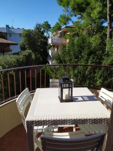 un tavolo bianco e sedie sul balcone di Appartamento Mirabell, FRONTE SPIAGGIA, VISTA MARE CON PARCHEGGIO a Grado