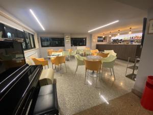 a dining room with tables and chairs and a pool table at Hotel Capri in San Benedetto del Tronto