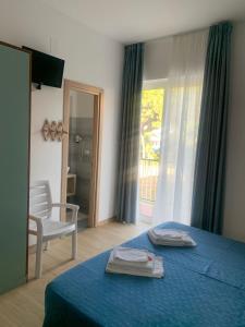 a bedroom with a blue bed with a chair and a window at Hotel Capri in San Benedetto del Tronto +36 photos