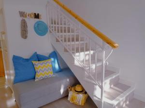 Una escalera blanca con un sofá debajo. en Bungalow los Majuelos, en Gran Alacant