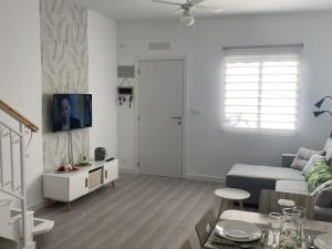 a white living room with a couch and a table at Bungalow los Majuelos in Gran Alacant