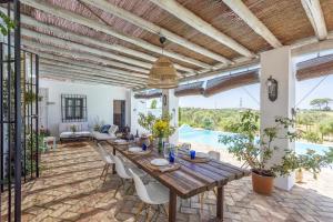 a dining room with a table and chairs and a pool at Hacienda San Antonio in Marchena