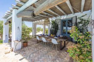 an outdoor patio with a wooden table and chairs at Hacienda San Antonio in Marchena